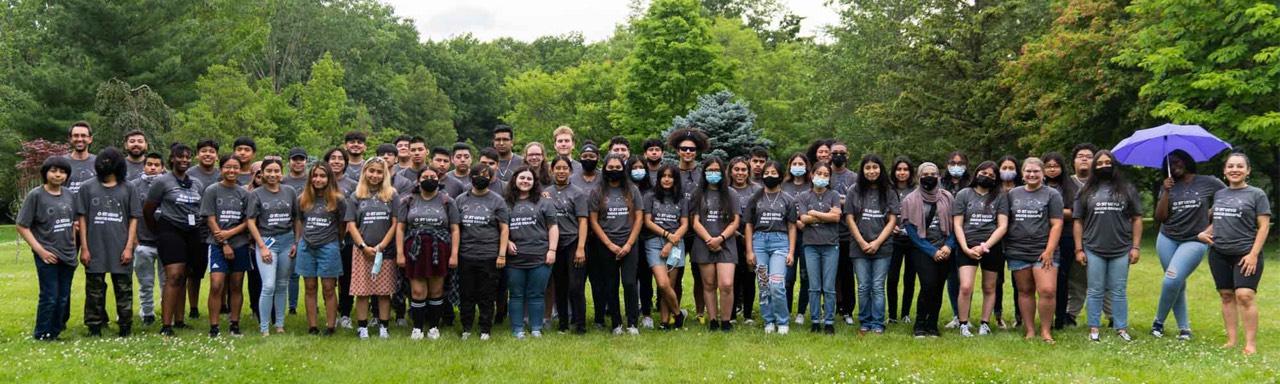 group of TRIO UB students and staff smiling at camera standing in the grass